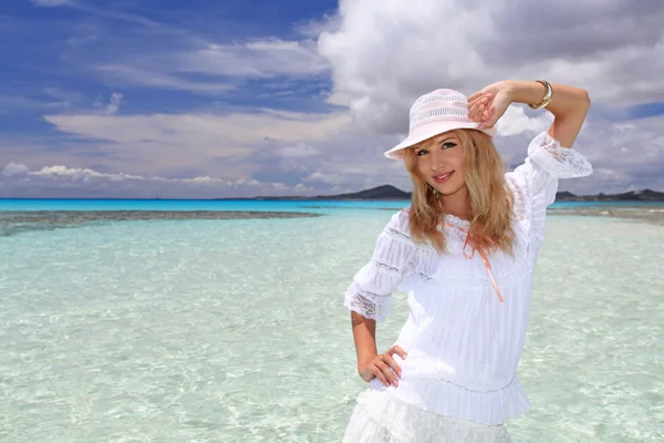 Mooie jonge vrouw op het strand genieten van zonlicht — Stockfoto