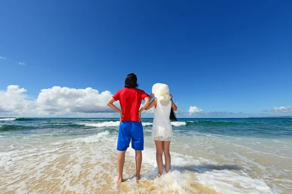 Młody mężczyzna i kobieta na plaży cieszyć się światło słoneczne — Zdjęcie stockowe