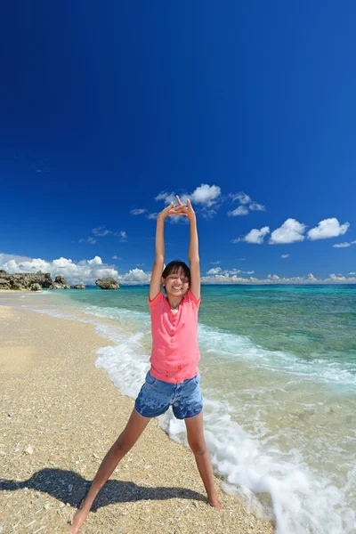 Девушка делает растяжку на пляже — стоковое фото