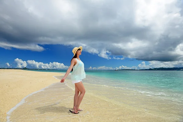 Jeune femme sur la plage profiter de la lumière du soleil — Photo