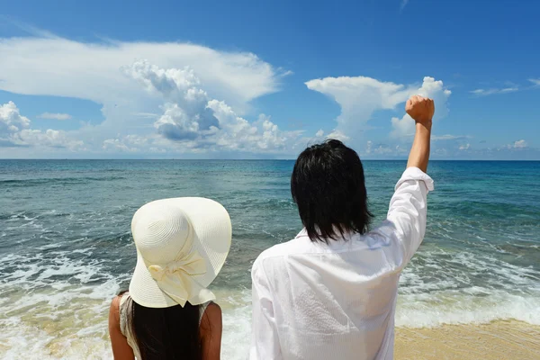 Young man and woman on the beach enjoy sunlight — Stock Photo, Image