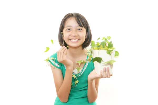 Ragazza sorridente con pianta — Foto Stock
