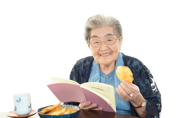 Yaşlı kadın ona kitap okuma — Stok fotoğraf