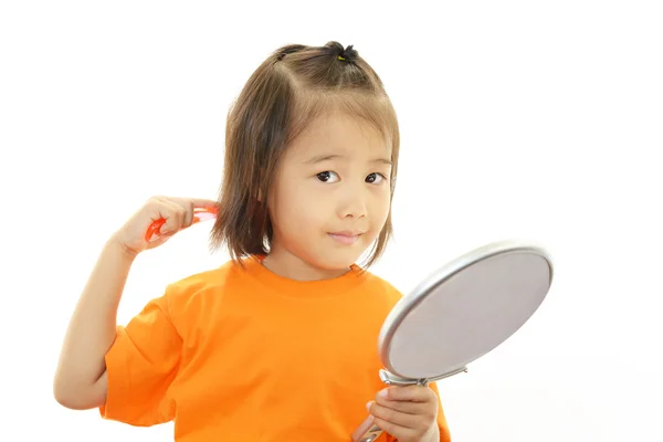 Niña peinándose el pelo — Foto de Stock