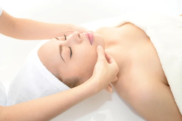 Beautiful young woman receiving facial massage — Stock Photo, Image