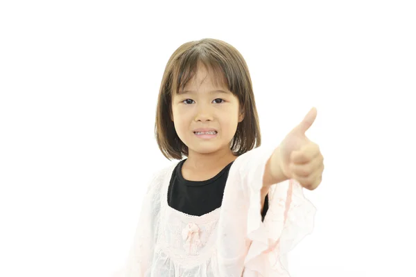 快乐的小女孩与竖起大拇指 免版税图库图片
