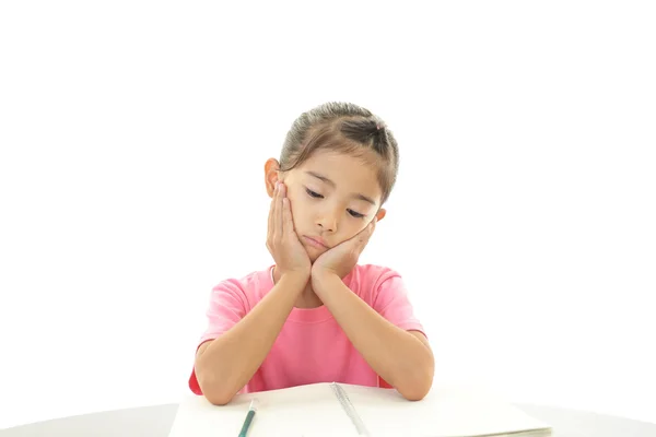 Chica estudiando en el escritorio cansada — Foto de Stock