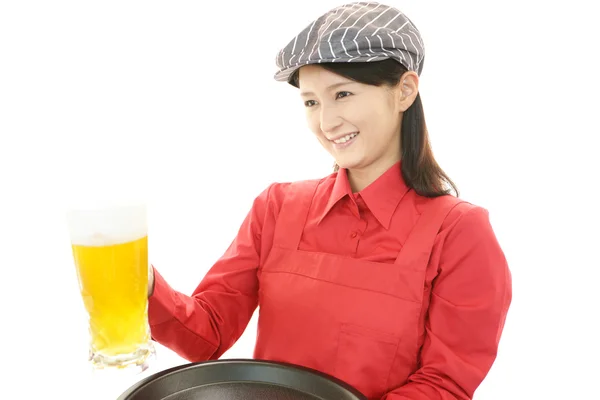 Smiling waitress carrying a beer — Stock Photo, Image
