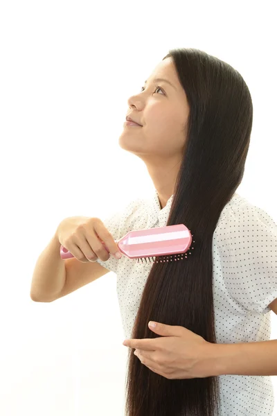 Mulher bonita escovando seu cabelo — Fotografia de Stock