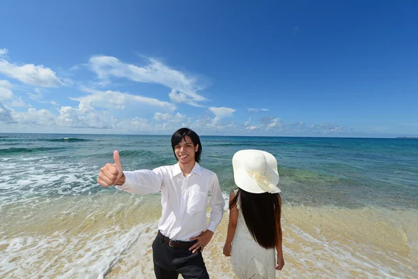 Молодой человек и женщина на пляже наслаждаются солнечным светом — стоковое фото