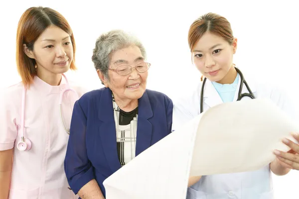Asian medical staff with old woman — Stock Photo, Image