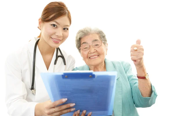 Ασιατικές ιατρικό προσωπικό με την γριά — Φωτογραφία Αρχείου