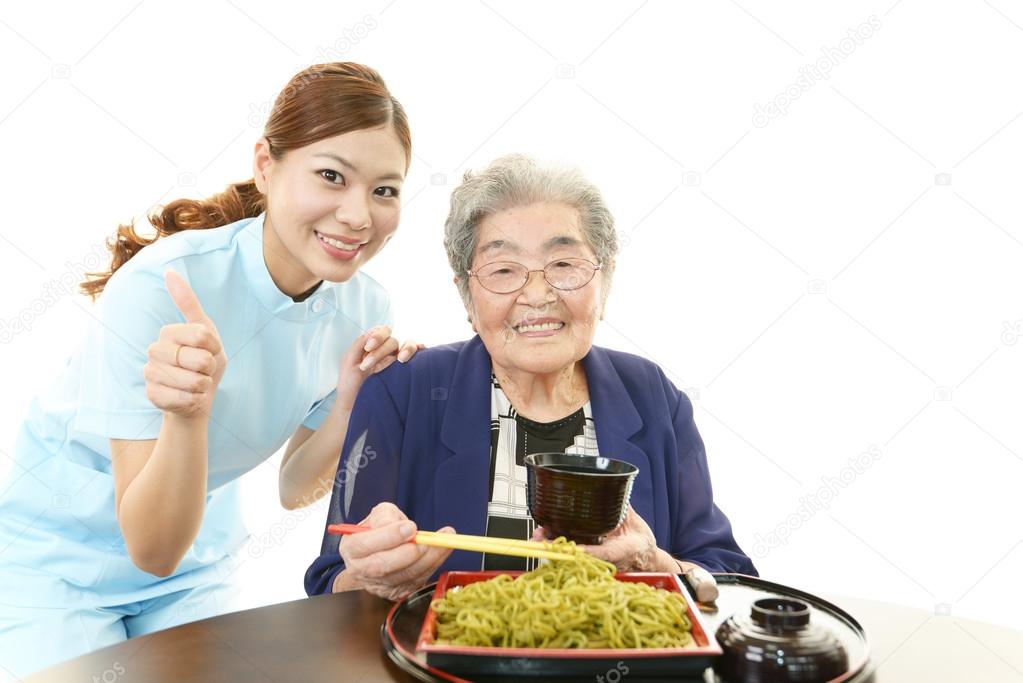 Friendly nurse cares for an elderly woman