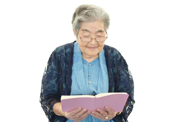 Vieille femme lisant son livre — Photo