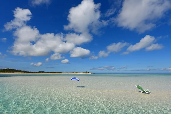 Ombrellone su una spiaggia soleggiata con il mare azzurro sullo sfondo . — Foto Stock