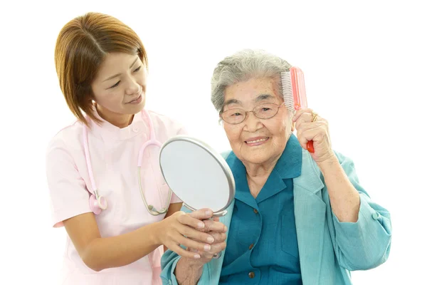 Oude vrouw haar haren kammen — Stockfoto