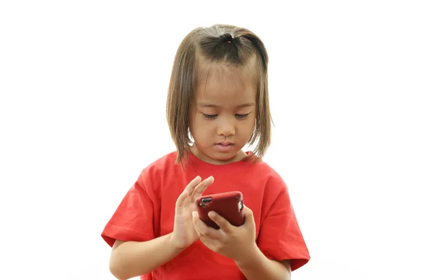Bir cep telefonu tutan küçük bir kız — Stok fotoğraf