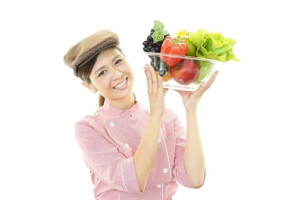 Smiling waitress holding vegetables — Stock Photo, Image