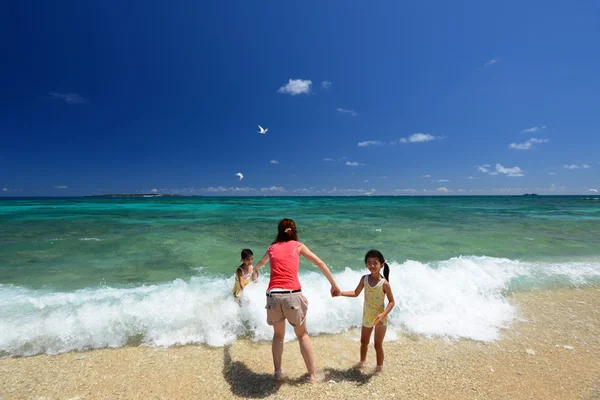 Familj spelar på stranden — Stockfoto