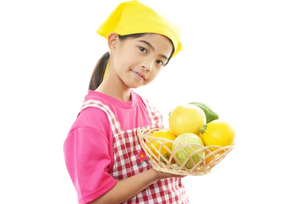 Asiatische Mädchen mit einem Korb voller Früchte — Stockfoto