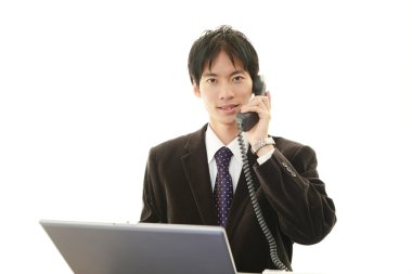 telefon ile gülümseyen Asya iş adamı