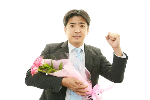 Smiling businessman with flower — Stock Photo, Image