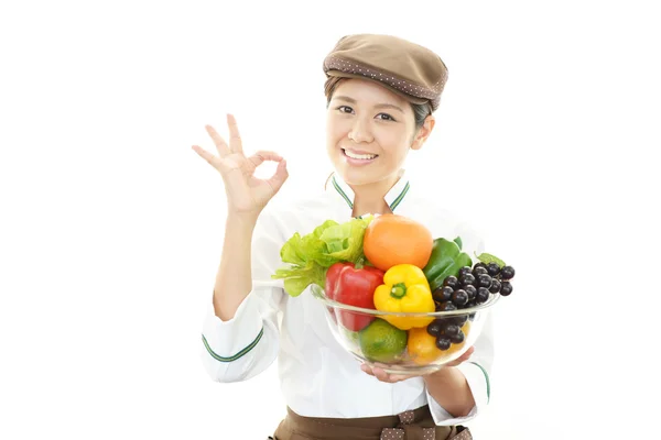 Glimlachend serveerster bedrijf groenten — Stockfoto