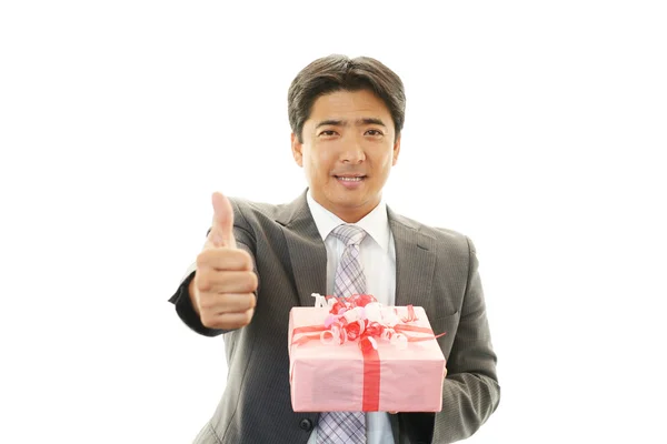 Lächelnder Geschäftsmann mit einem Geschenk — Stockfoto