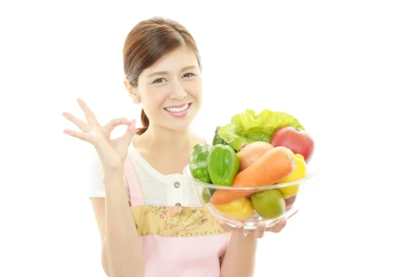 Lächelnde Kellnerin mit Gemüse — Stockfoto