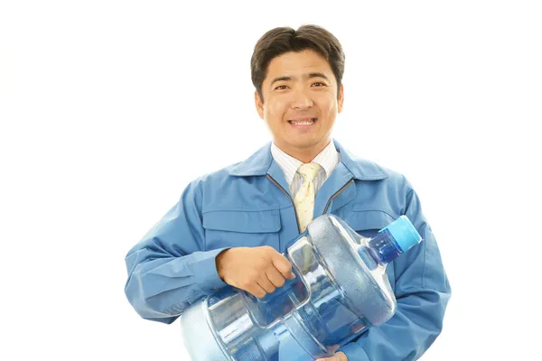 Trabalhador com um recipiente de água — Fotografia de Stock