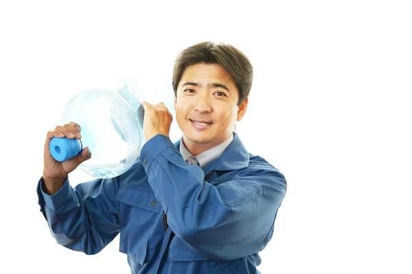 Trabalhador com um recipiente de água — Fotografia de Stock