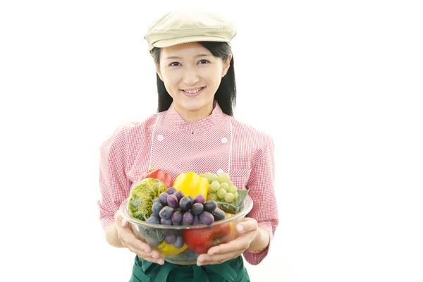 Smiling waitress holding vegetables — Stock Photo, Image