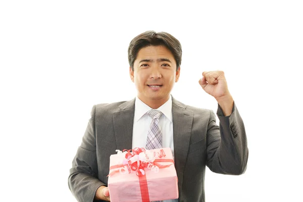 Smiling businessman with a gift — Stock Photo, Image