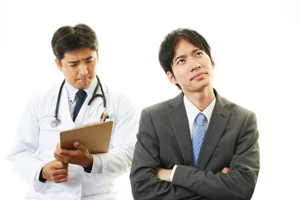 Médico examinando um paciente — Fotografia de Stock