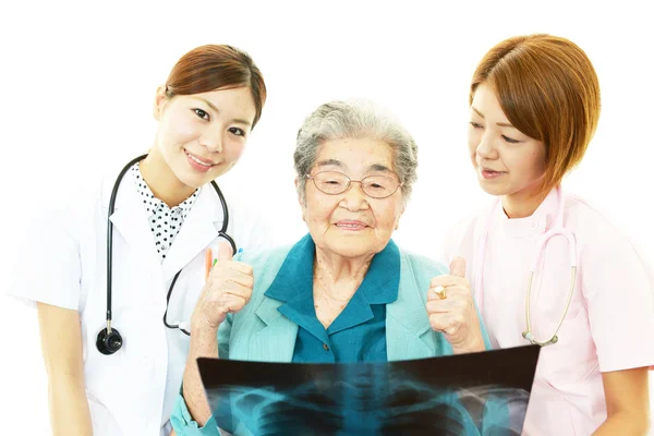 Äldre kvinna med medicinsk personal — Stockfoto