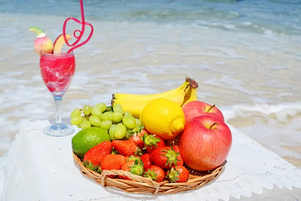 Frutos frescos e uma bebida na praia — Fotografia de Stock