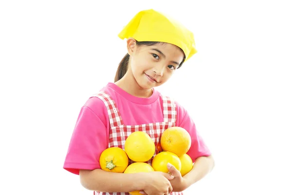 Ragazza sorridente che tiene frutta — Foto Stock