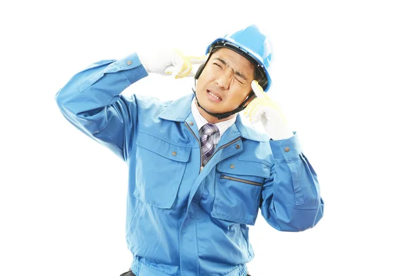 Уставший и напряженный азиатский рабочий — стоковое фото