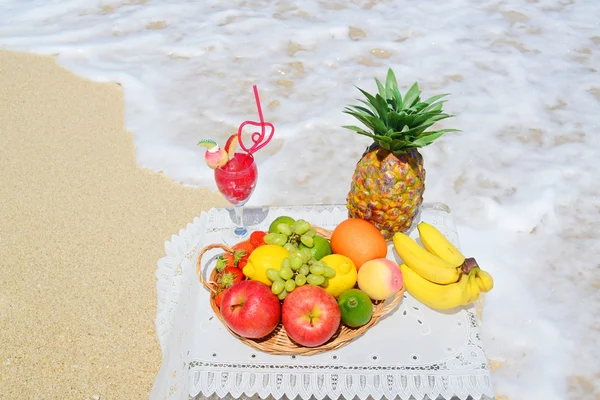 Fresh fruits and a drink on the beach — Stock Photo, Image