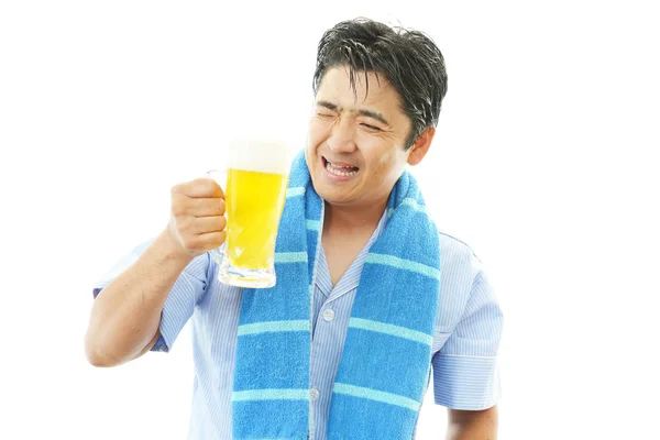 Smiling Asian man drinking beer — Stock Photo, Image