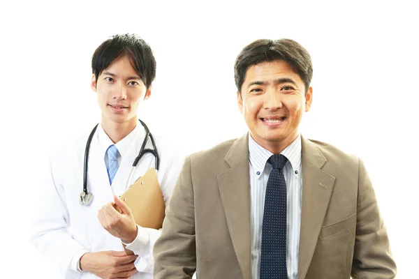 Smiling Asian medical doctor and patient — Stock Photo, Image