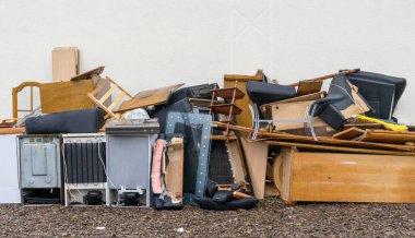 Bulky garbage heap in front of a house wall