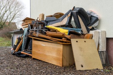 Bulky garbage heap in front of a house wall