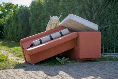 Bulky garbage heap at the roadside with upholstered furniture
