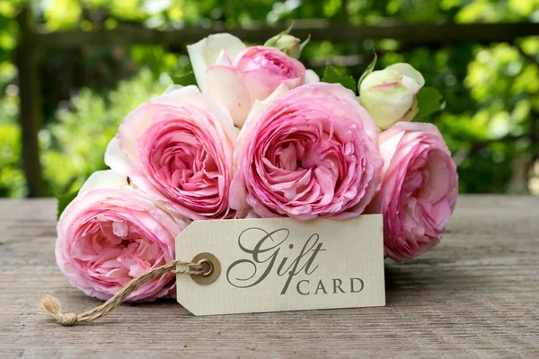 ピンクのバラの花束とギフト券 — ストック写真