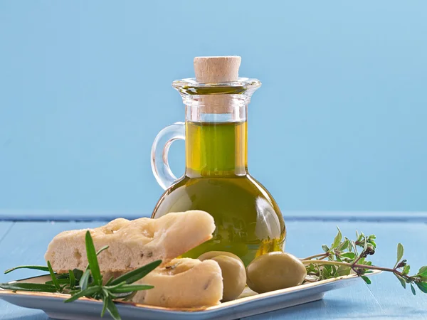 Una botella de aceite de oliva con aceitunas y hierbas —  Fotos de Stock