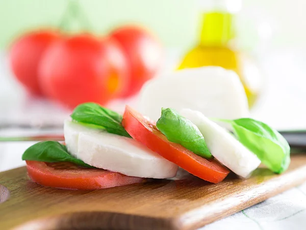 Tomatoes with mozzarella and basil — Stock Photo, Image