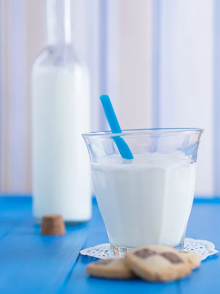 Ein Glas Milch mit Keksen und einem Strohhalm — Stockfoto