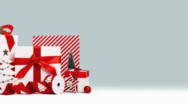 Kırmızı ve beyaz hediye kutuları ve mavi arka planda Noel ağaçları olan süsler. Çeşitli boyutlarda. Mutlu Noeller ve mutlu yıllar hediye alışverişi ve satış konsepti