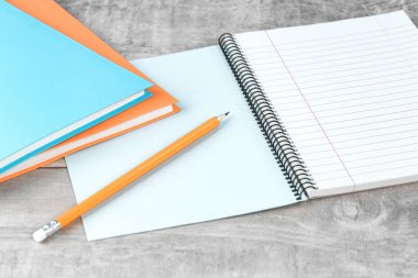 İş ya da eğitim ya da öğrenim ve gelişme ve başarı kavramı. Gri ofiste ya da mavi arka planı olan çalışma masasında açık defter ve bir kalem. Test ya da sınav. Boşluğu kopyala